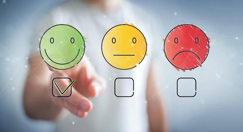 A blurred customer makes a positive selection on a satisfaction rating system