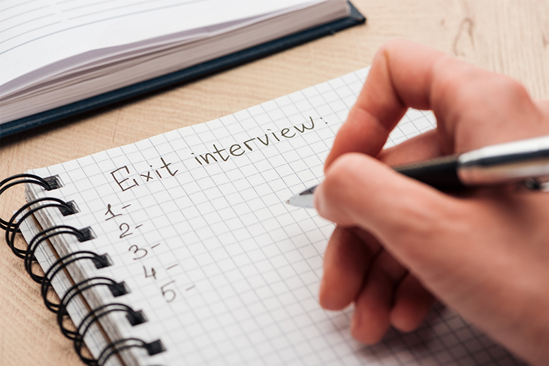 An HR manager begins to jot down exit interview questions to ask an employee