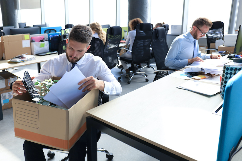 Employee affected by recent layoffs boxes up his office items.