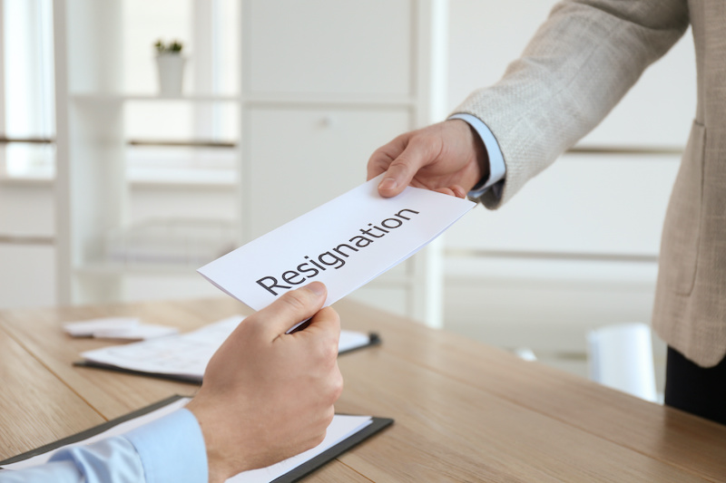 An employee hands a resignation letter to his manager, who will have to inform his staff of the employee resignation