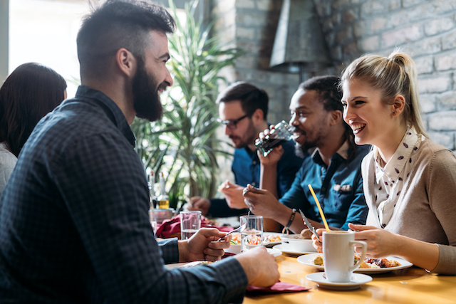 Employees enjoy a team lunch that helps to boost rapport and morale.