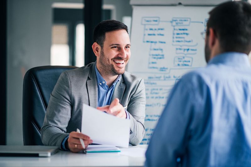 A male hiring manager who understands how to hire employees meets with a male candidate.