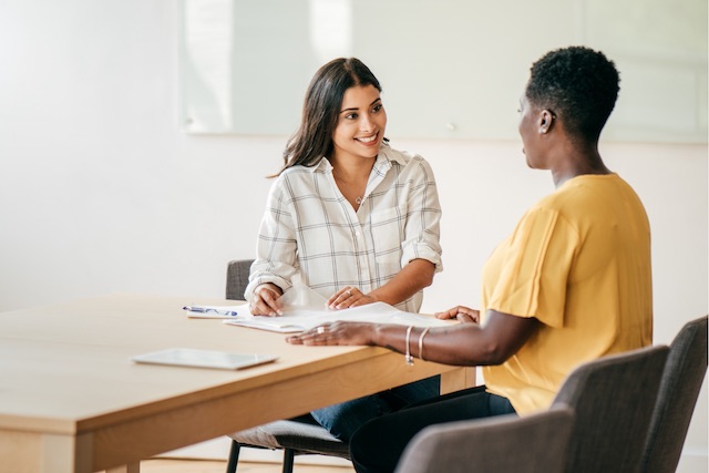 To know how to increase employee satisfaction, it helps to interview employees to understand their goals and needs, like this manager who is meeting with her employee.