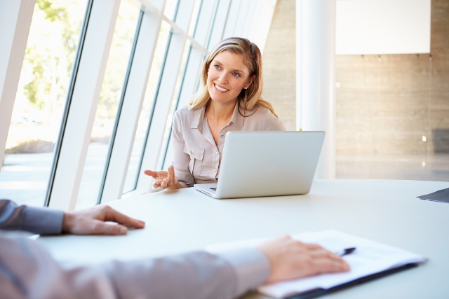 Picture of female sat behind laptop having a conversation