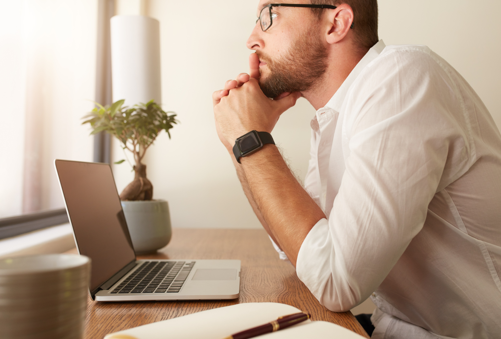 Man sitting at desk pondering a difficult conversation with a senior executive