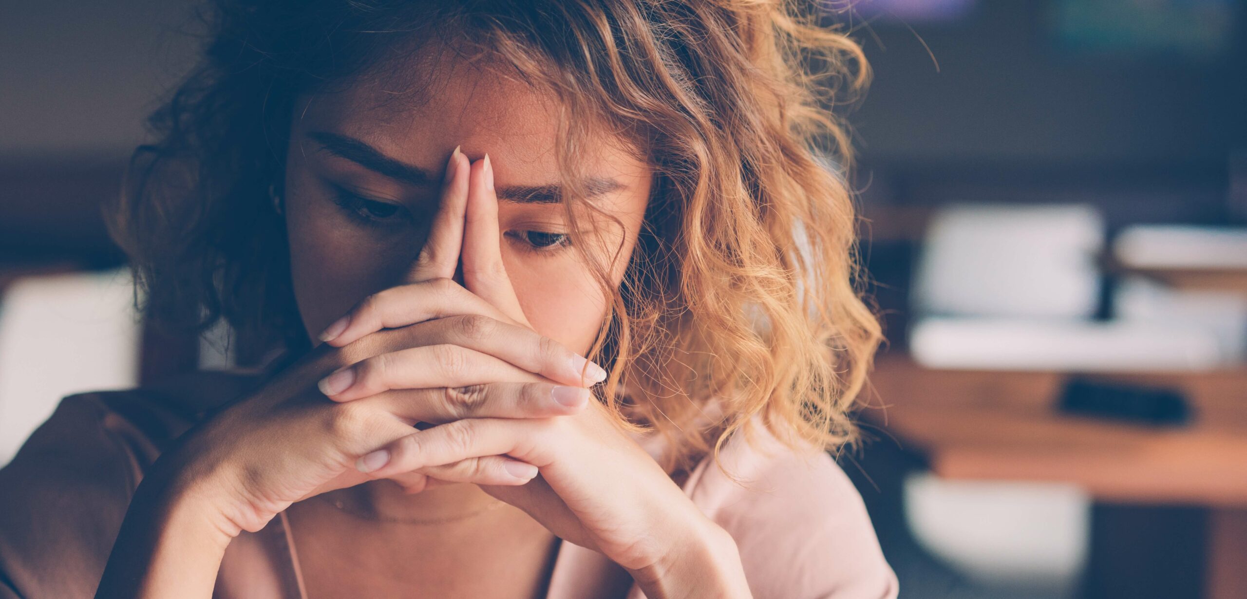 Woman experiencing burnout at work, looking tired and frustrated.