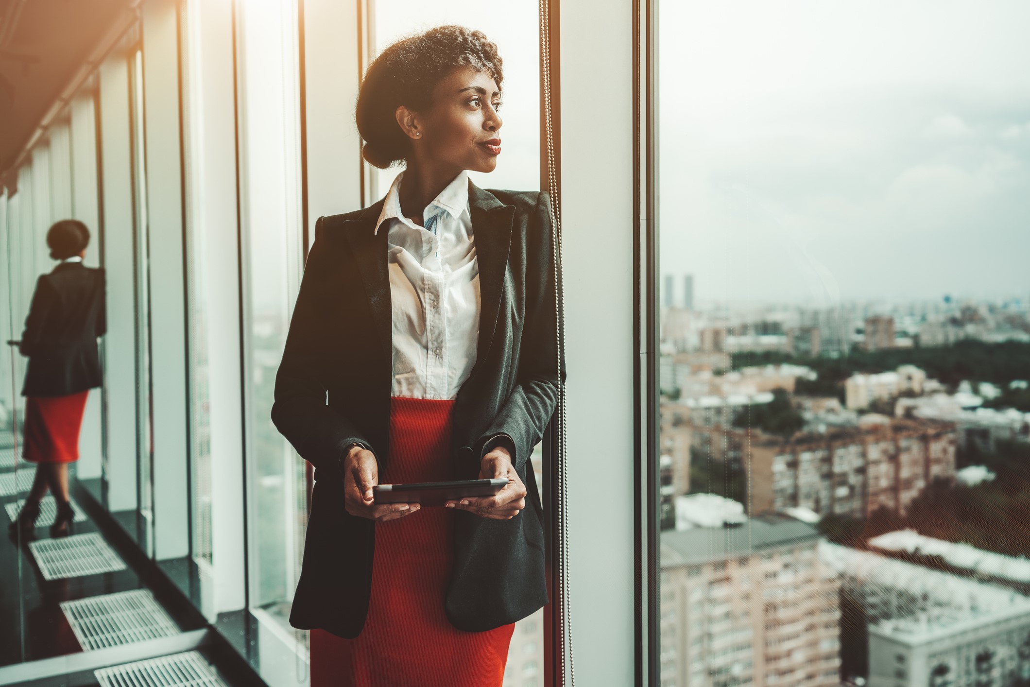 Business woman looking out of window contemplating