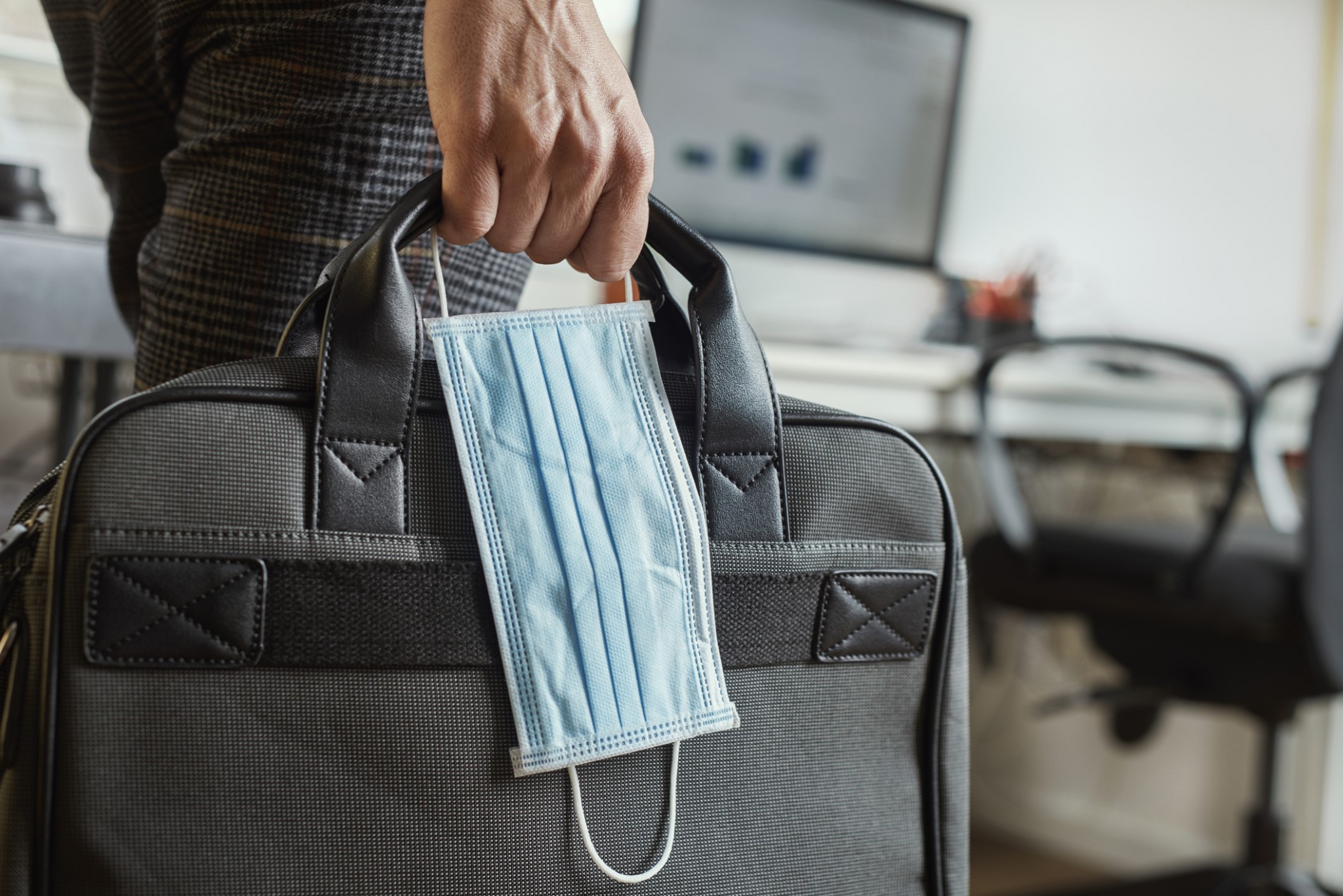 Man with a briefcase and a surgical mask