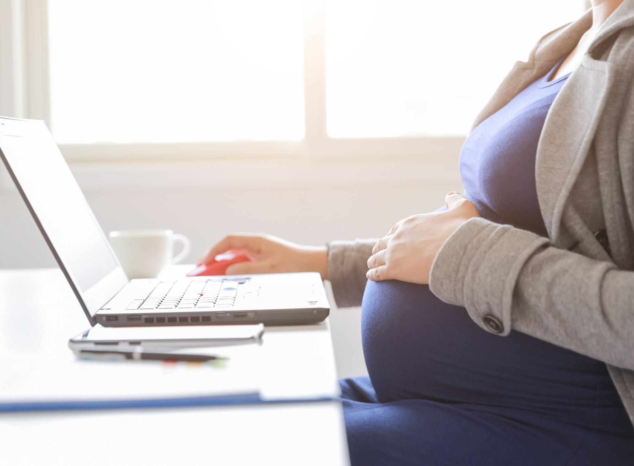 pregnant woman is working on computer laptop and mobile phone, business