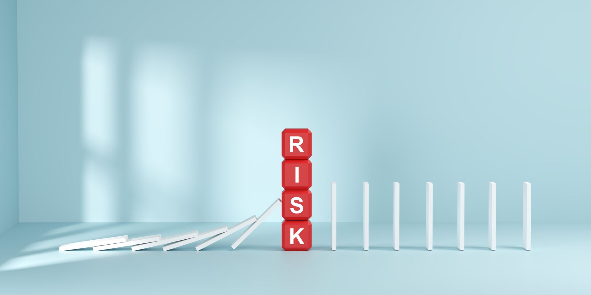 career-transition-risks-outplacement-hero Career transition risks: a red RISK block stopping a row of falling dominoes