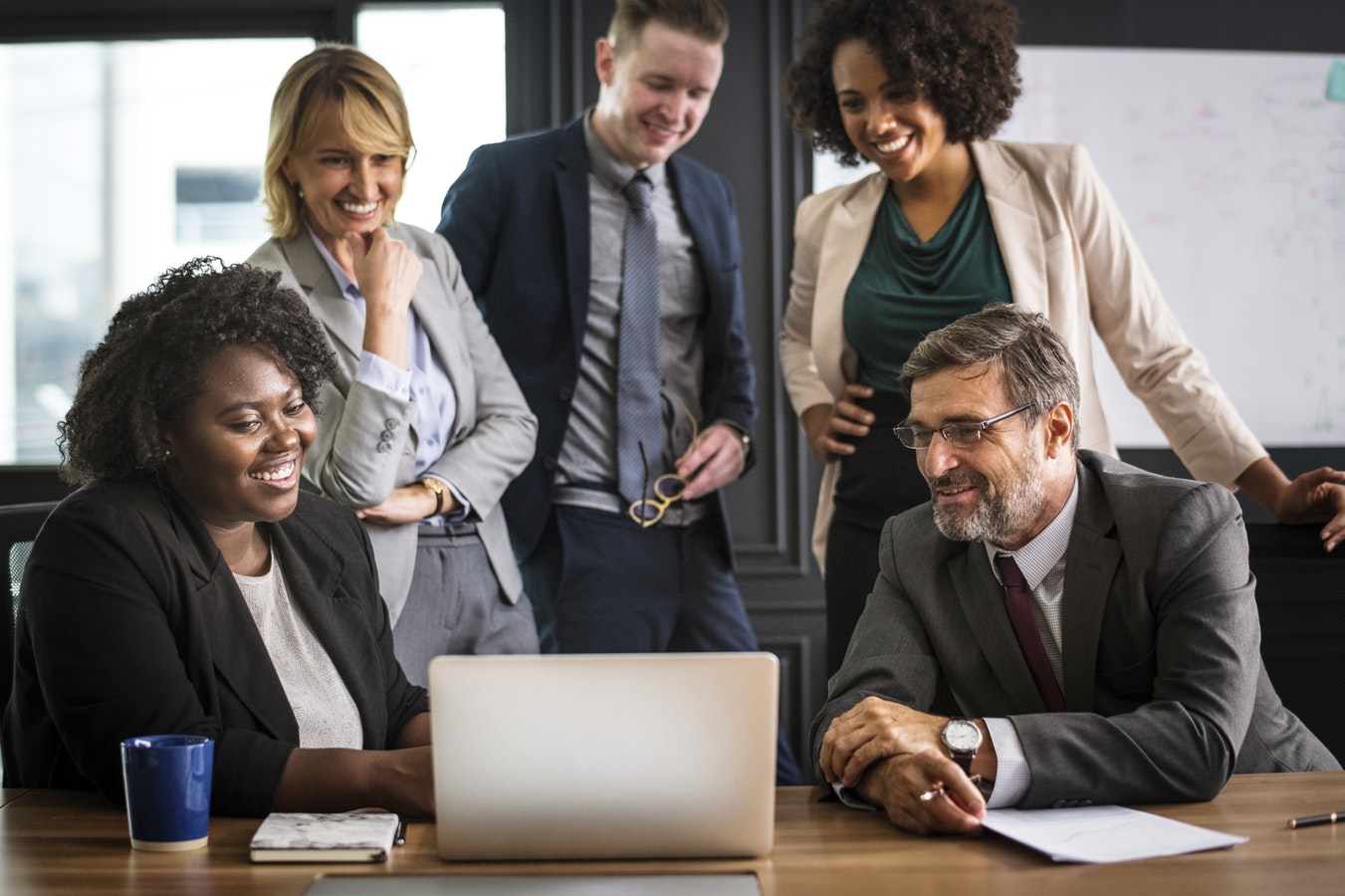 gruppo di impiegati che sorridono intorno a un computer