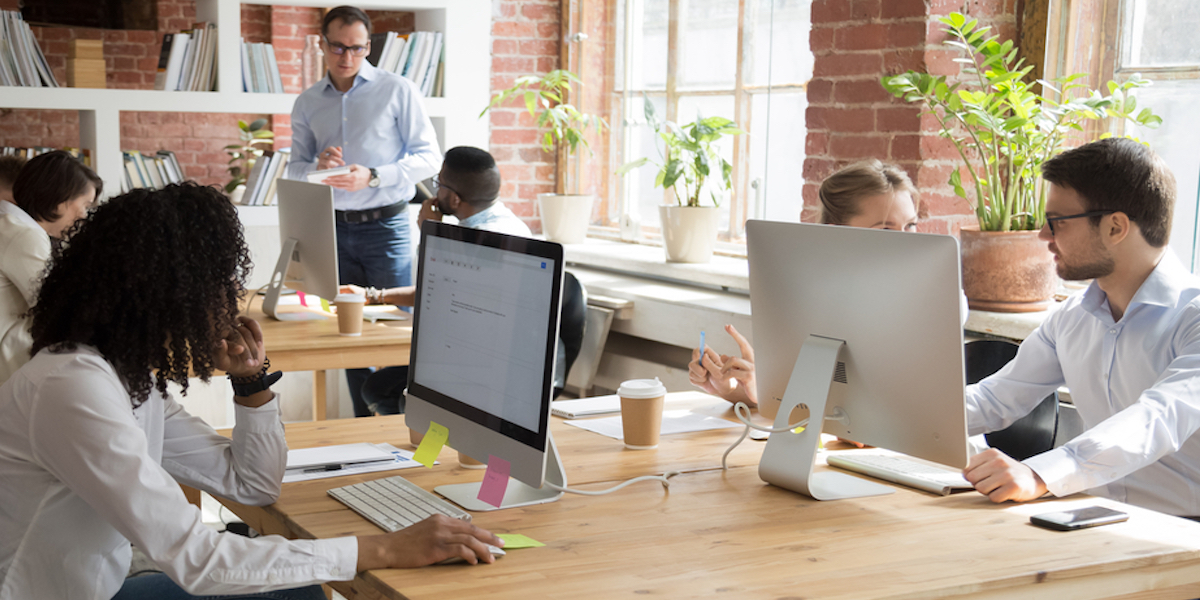 A young Black woman leads her team in a project meeting