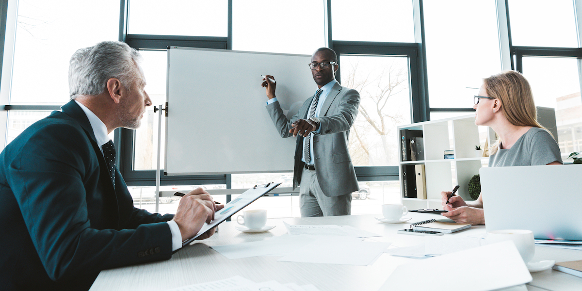 A young Black woman leads her team in a project meeting