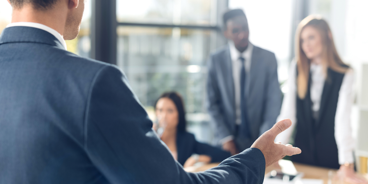 A young Black woman leads her team in a project meeting