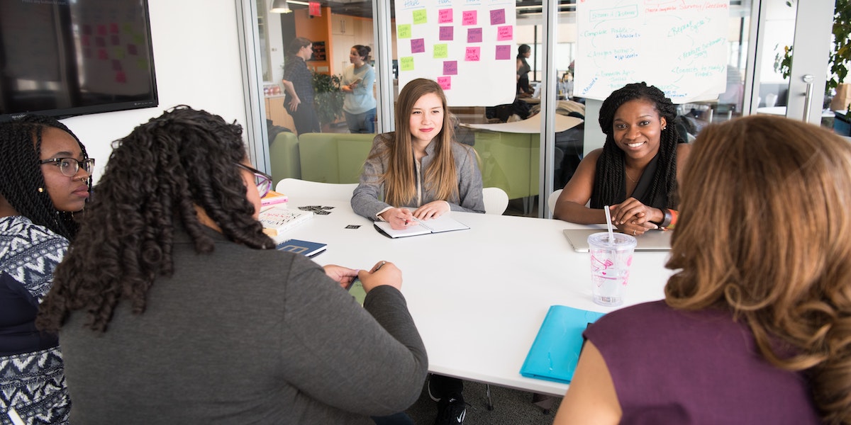 A young Black woman leads her team in a project meeting