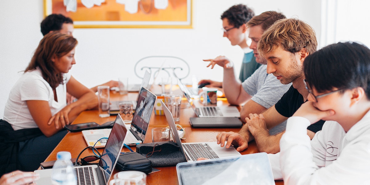 A young Black woman leads her team in a project meeting