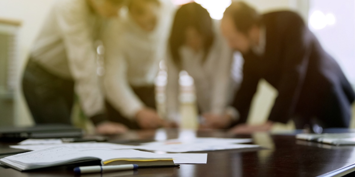 A young Black woman leads her team in a project meeting