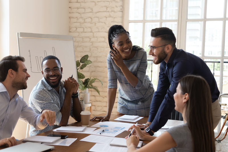 A young Black woman leads her team in a project meeting