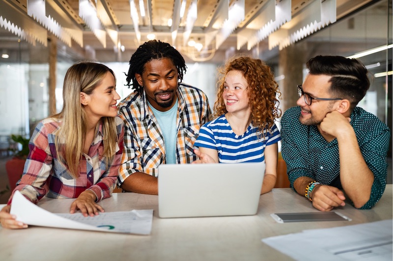 A young Black woman leads her team in a project meeting