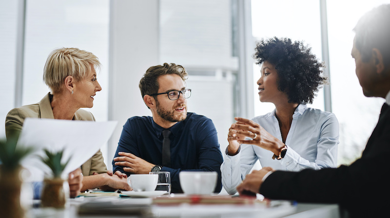 A young Black woman leads her team in a project meeting