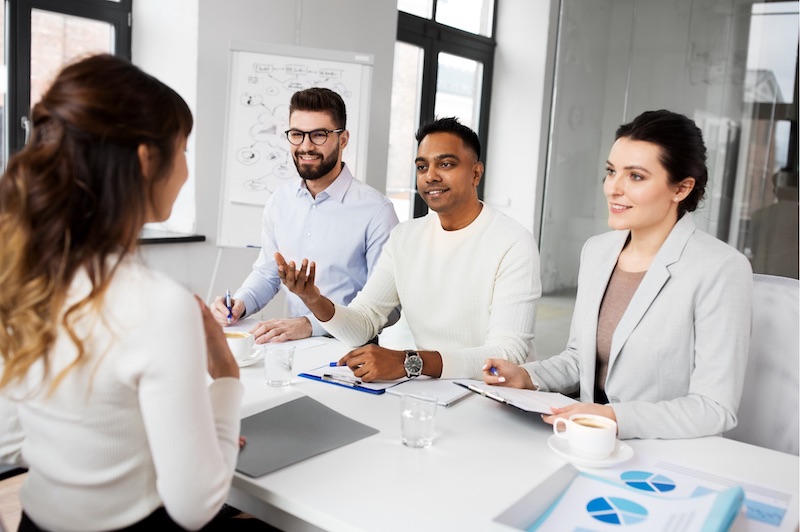 A young Black woman leads her team in a project meeting