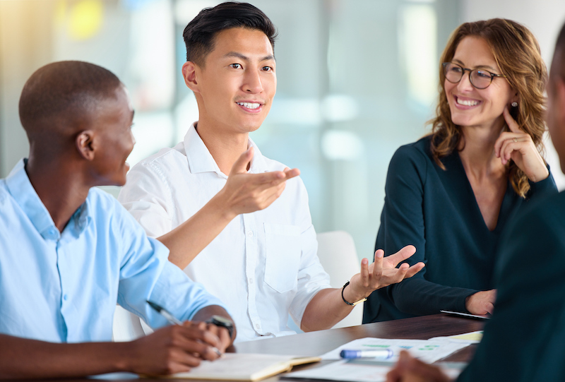 A young Black woman leads her team in a project meeting