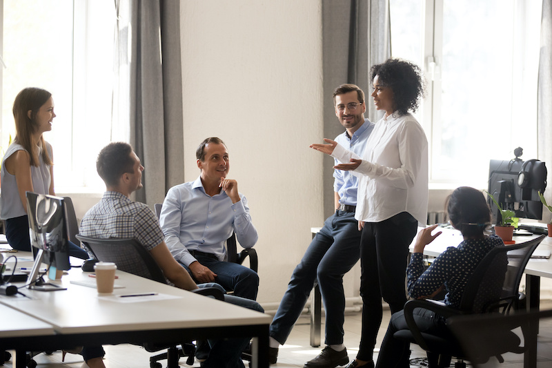 A young Black woman leads her team in a project meeting