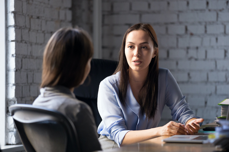 A young Black woman leads her team in a project meeting