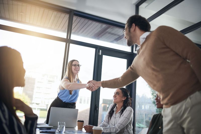 A young Black woman leads her team in a project meeting