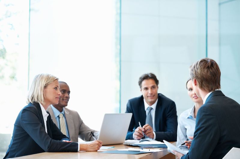 A young Black woman leads her team in a project meeting