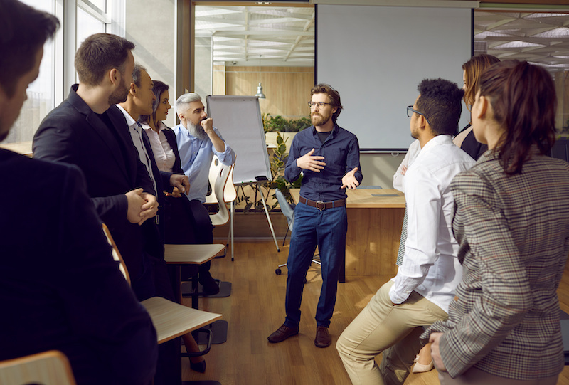 A young Black woman leads her team in a project meeting