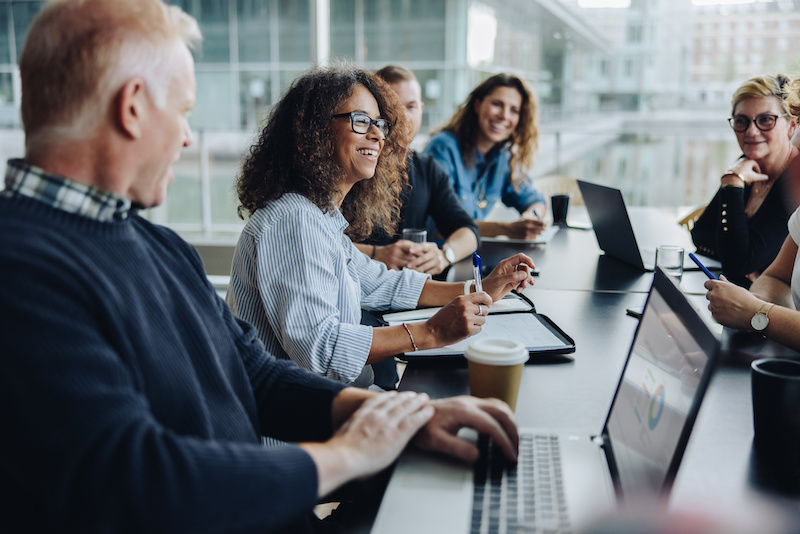 A young Black woman leads her team in a project meeting