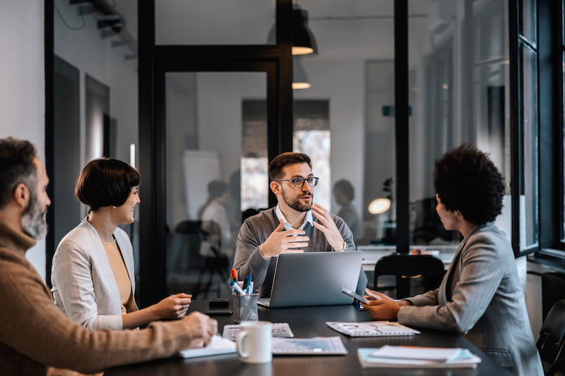 A young Black woman leads her team in a project meeting