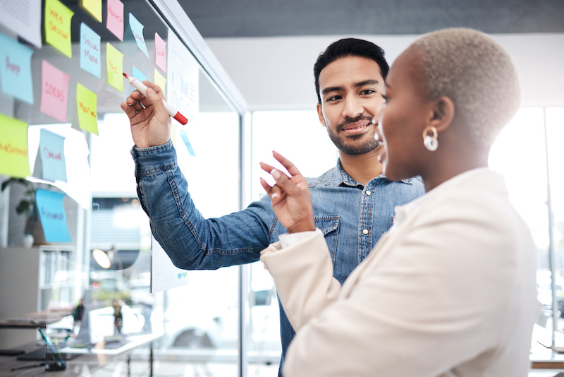 A young Black woman leads her team in a project meeting