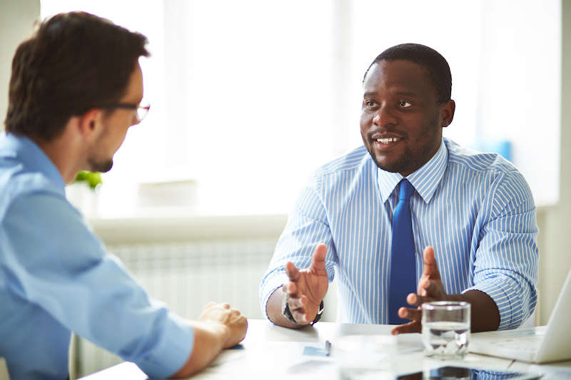 A young Black woman leads her team in a project meeting