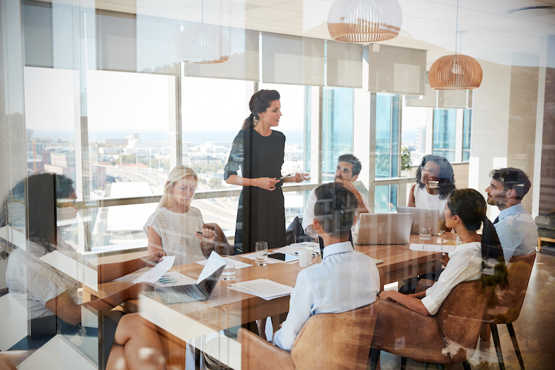 A young Black woman leads her team in a project meeting