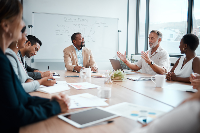 A young Black woman leads her team in a project meeting