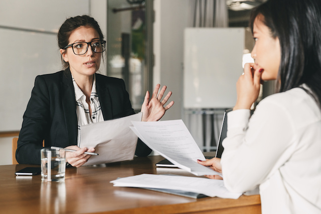 A female HR manager meets gives a layoff notice to a female employee along with severance information.