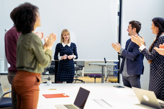 Colleagues celebrate their female coworker for her promotion