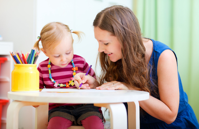 A mother draws with her young daughter