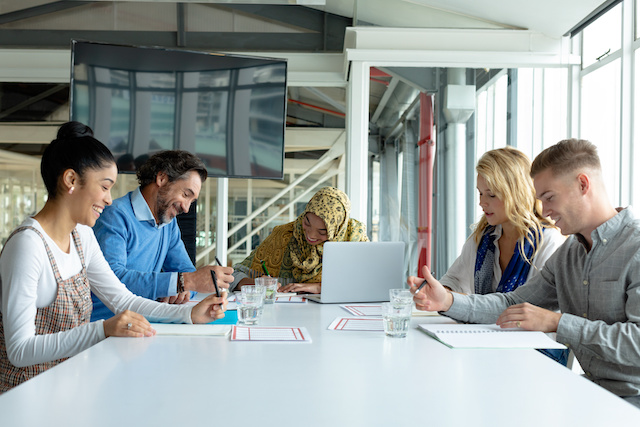 A diverse group of colleagues work in a conference room