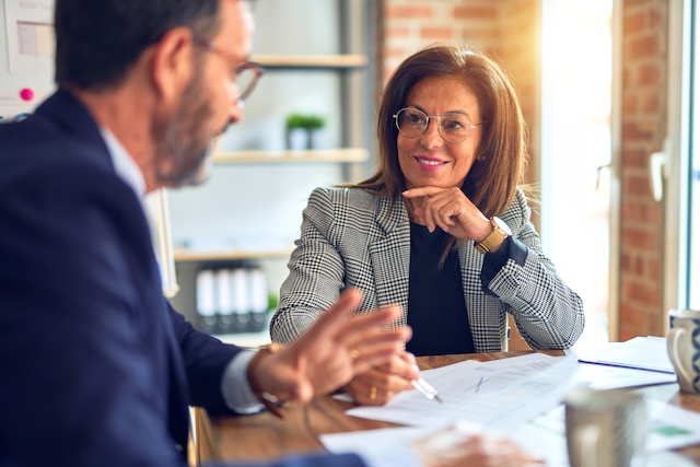 A female senior director gives her male direct report a manager performance review