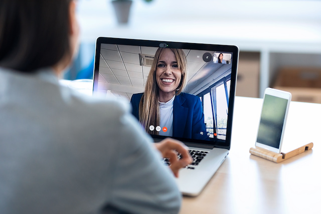 A woman has a video call with a female career transition coach on her laptop