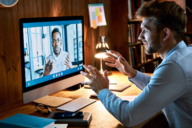 Two male coworkers meet virtually to collaborate on a project.