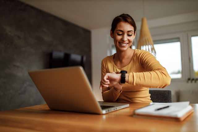 A female part-time employee looks at her watch