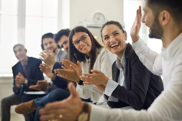 Happy employees applaud one worker's idea