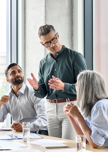 Middle-aged career coach addresses employees during a workshop