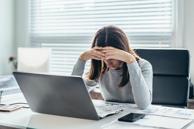 After recent layoffs, a woman reacts to learning her fate during a remote meeting.