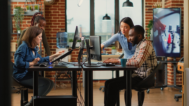 Diverse engineers collaborate in an office.