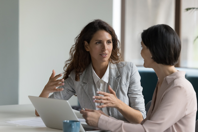 A female manager has a one-on-one meeting with her female employee.